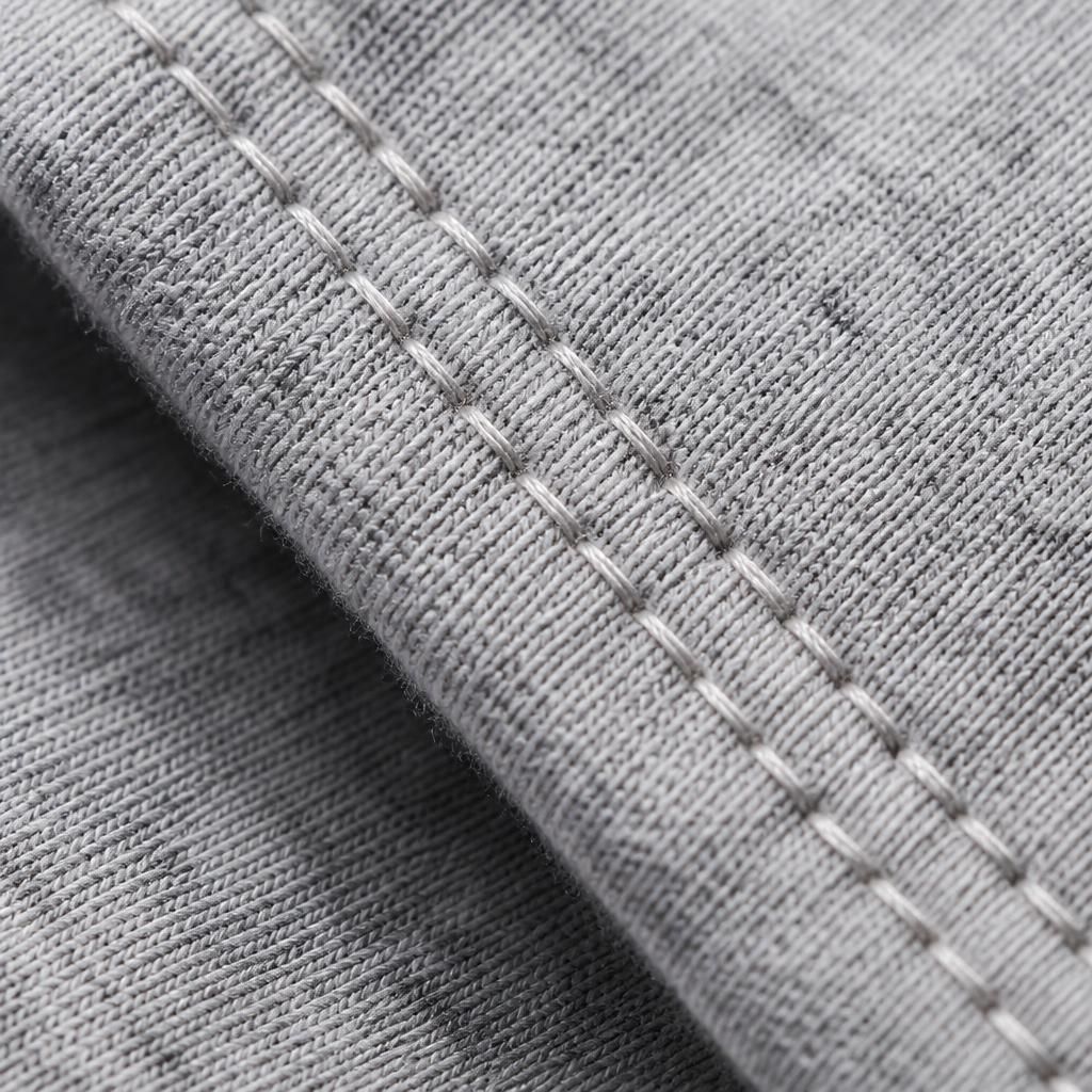 Extreme macro photograph of a double-needle stitched hem on a cotton garment